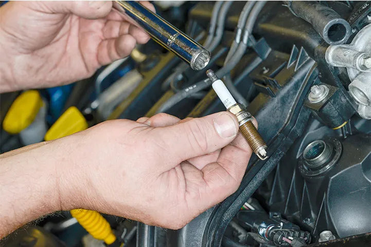 What is a spark plug and what does it do?