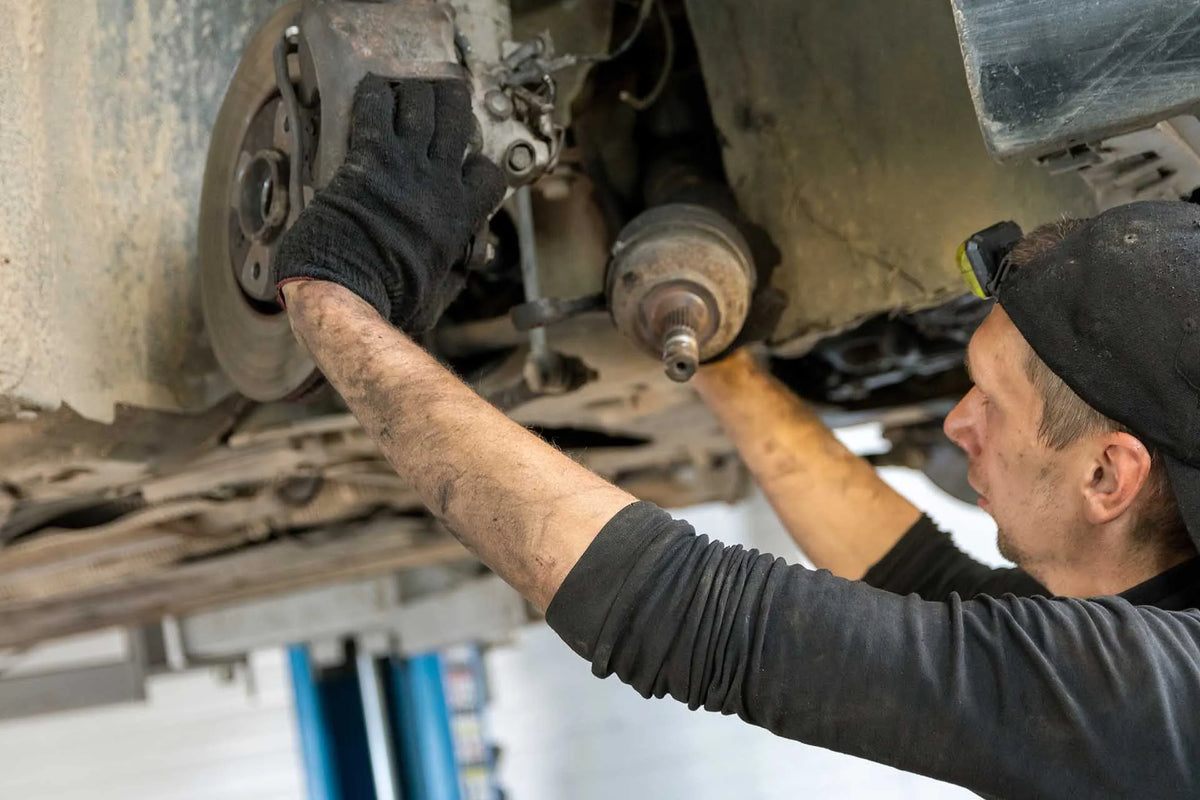 A mechanic fitting a drive shaft