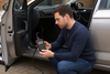 Man using OBD reader to look at a modern UK car