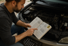someone using a haynes manual to fix a car